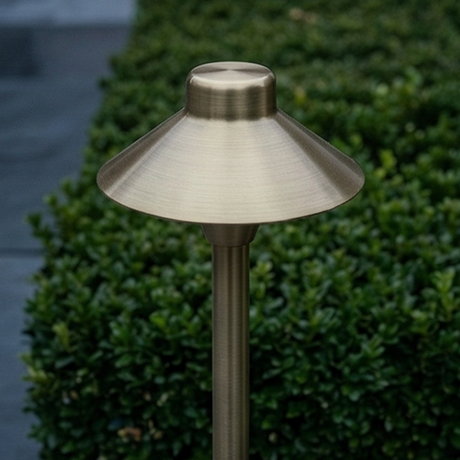 Close-up of a high-quality brass path light showcasing its elegant design and durable construction, ideal for landscape lighting projects.