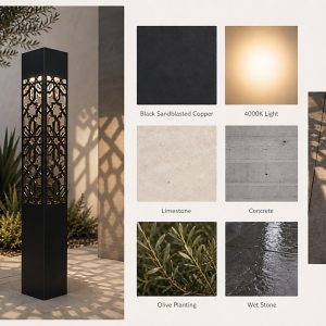 A black, rectangular geometric bollard light with an intricate, laser-cut pattern casting a detailed shadow on the paved ground. The light is situated outdoors in a landscaped setting with an olive tree and architectural plants.